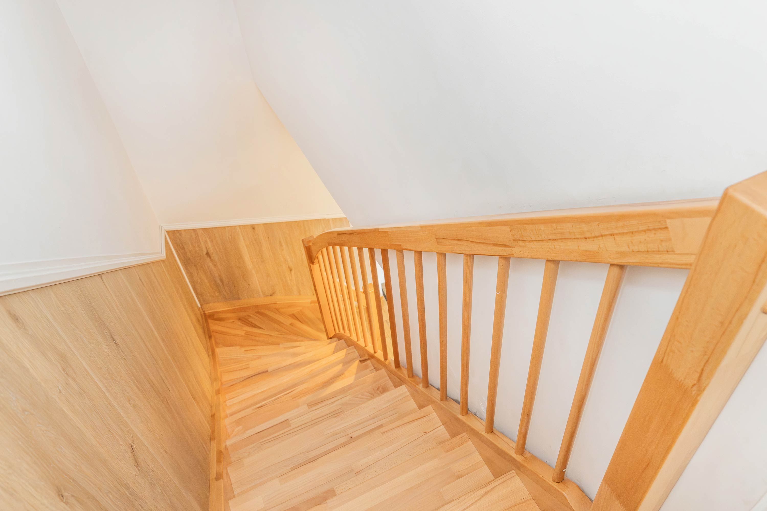 Eine Holztreppe mit Handlauf und Holzboden.