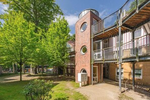 A multi-story building with a brick facade, circular windows, and a balcony with a metal railing. - A gorgeous vacation rental in Koserow on the pier, right on the Baltic Sea beach, featuring (Koserow)