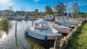 A marina with boats docked, calm water, and a clear sky. - Modern vacation rental in Kölpinsee with a balcony—just 600 m from the beach (Ostseebad Kölpinsee)