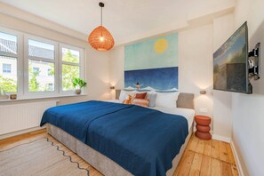 Ein Schlafzimmer mit einem großen Bett, einem Fenster mit Blick, einem an der Wand montierten Fernseher und einem Gemälde.