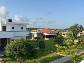 A residential area with a modern house, a well-maintained lawn, and a clear sky.