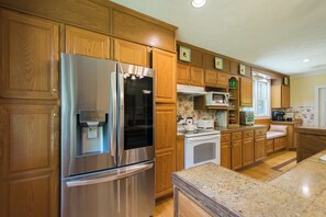 A kitchen with wooden cabinets, stainless steel appliances, a microwave, and a toaster.