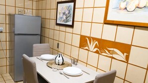 A dining area with a table set for two, a refrigerator, and a wall with a floral pattern. - AG19 • Apartment in downtown Milan • (Milano)