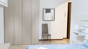 A bedroom with a bed, a chair, a wardrobe, and a door leading to another room. - AG19 • Apartment in downtown Milan • (Milano)
