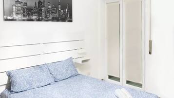 Tabla de planchar con plancha, internet y ropa de cama