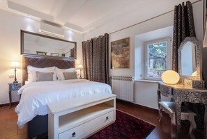 A bedroom with a bed, bedside tables, a dresser, a mirror, curtains, and a window with a view. - Charming 4-Bedroom Stone Villa with Pool & Garden, 15 Min to Dubrovnik (Knežica)