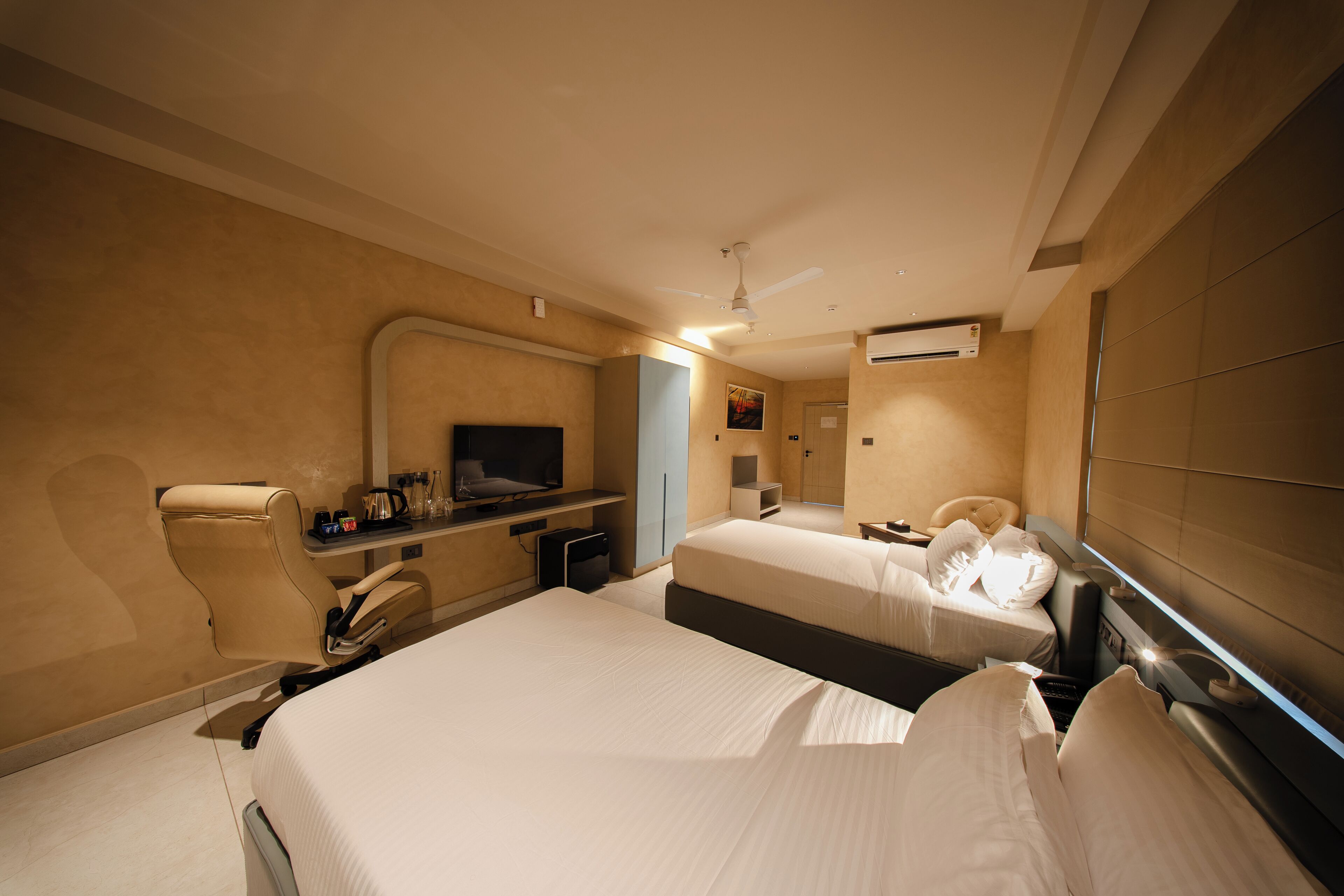 Une chambre d’hôtel avec deux lits, un bureau, une télévision et un appareil de climatisation.