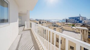 En balkon med udsigt over bybilledet, inklusive bygninger og en havn.