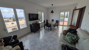 A spacious living area with a dining table, sofa, and TV. - Detached house with panoramic views near the ocean (El Poble Nou de Benitatxell/Benitachell)