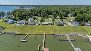 Vue aérienne d’un quartier résidentiel avec des maisons, un quai et une étendue d’eau.