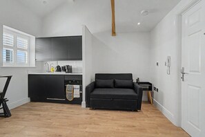 A compact living space with a kitchenette, a sofa, and a dining area. - Guestready - Duke Street (Liverpool)
