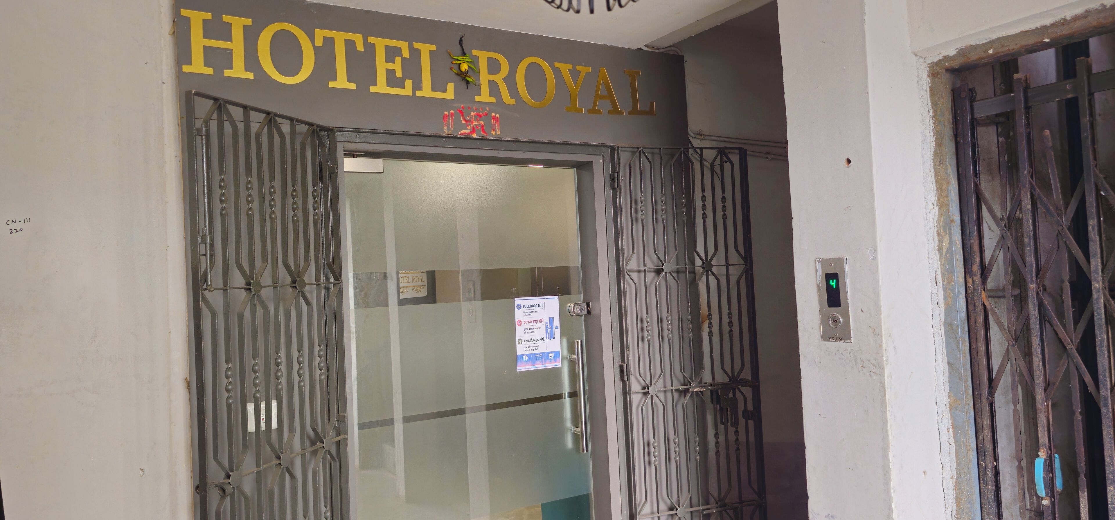 L'ingresso di un hotel con un cancello in metallo e un cartello che riporta 'HOTEL ROYAL'.