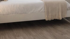 Un dormitorio minimalista con cama, mesita de noche y ventana.