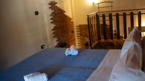 Et hotelværelse med en seng, en trætrap og et gelænder.