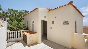 A building with a sign reading 'CASA BELLA,' a tiled entrance, and a small garden area with plants. - Casa Bella 1 - Apartment with Sea and Beach Views (Costa Calma)