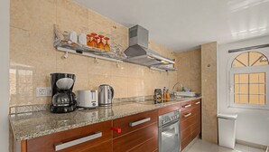 Een koffiezetapparaat/waterkoker, een koelkast, een magnetron, een oven