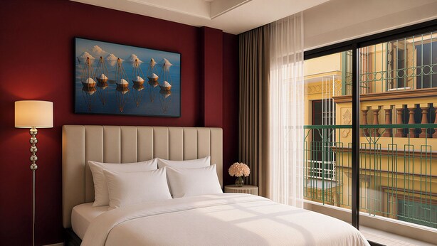 A hotel room with a large bed, a painting, a floor lamp, and a view of a building through a window. - Centraltique Passage Living (Hanoi)