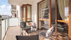 A balcony with a table, chairs, and a sofa. - Spacious Apartment with a Balcony | Parking | 2 Bedrooms (Toruń)