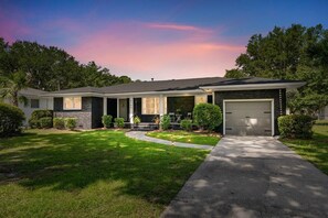 A two-story house with a garage, a covered front porch, and a well-maintained lawn. - The Tranquil Token-hot Tub & Ping Pong Table (North Charleston)