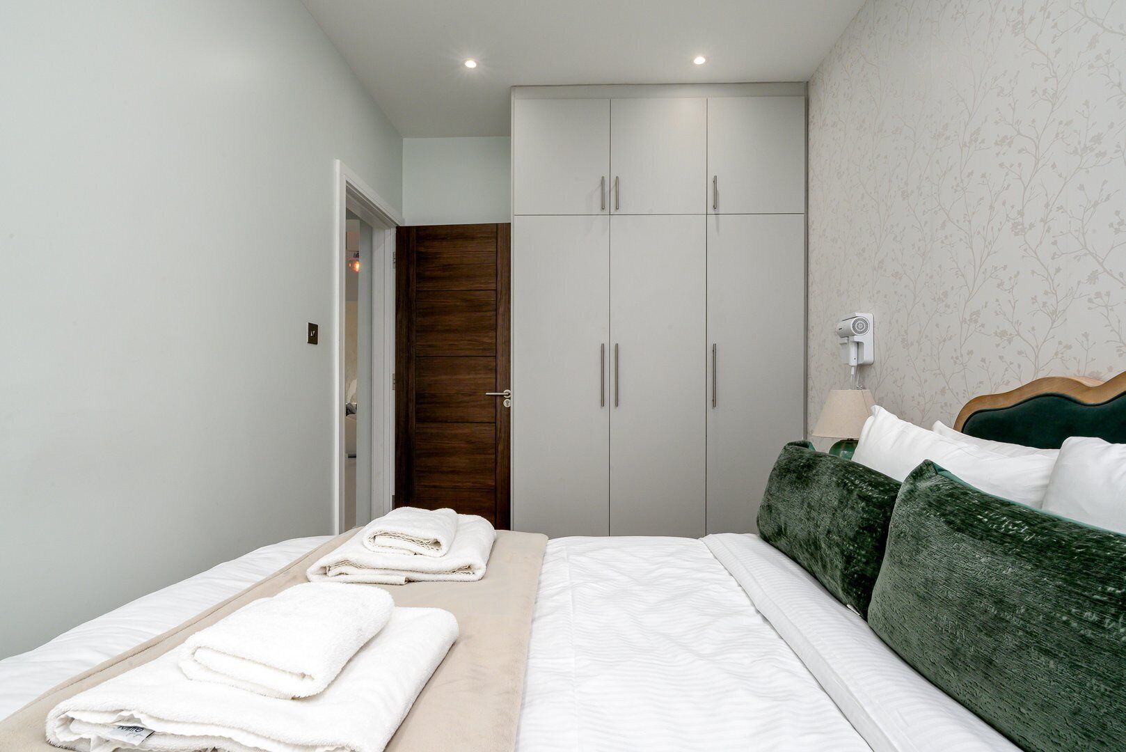 Un dormitorio con cama, armario y puerta de baño.