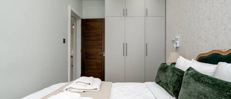 Un dormitorio con cama, armario y puerta de baño.
