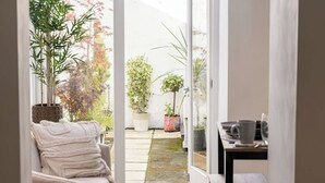 A cozy indoor space with a sofa, a table with a cup, and potted plants. - Stylish 3-Bed City Centre Home, Private Parking! (Chester)
