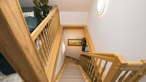 A wooden staircase with a handrail, carpeted steps, and a wall-mounted picture. - Exclusive Vacation Home on Lake Roofensee—Fireplace, Designer Kitchen, and Idyllic Natural Setting (Stechlin)
