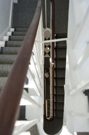 Una scala con corrimano, ringhiere in metallo e pavimento decorato.
