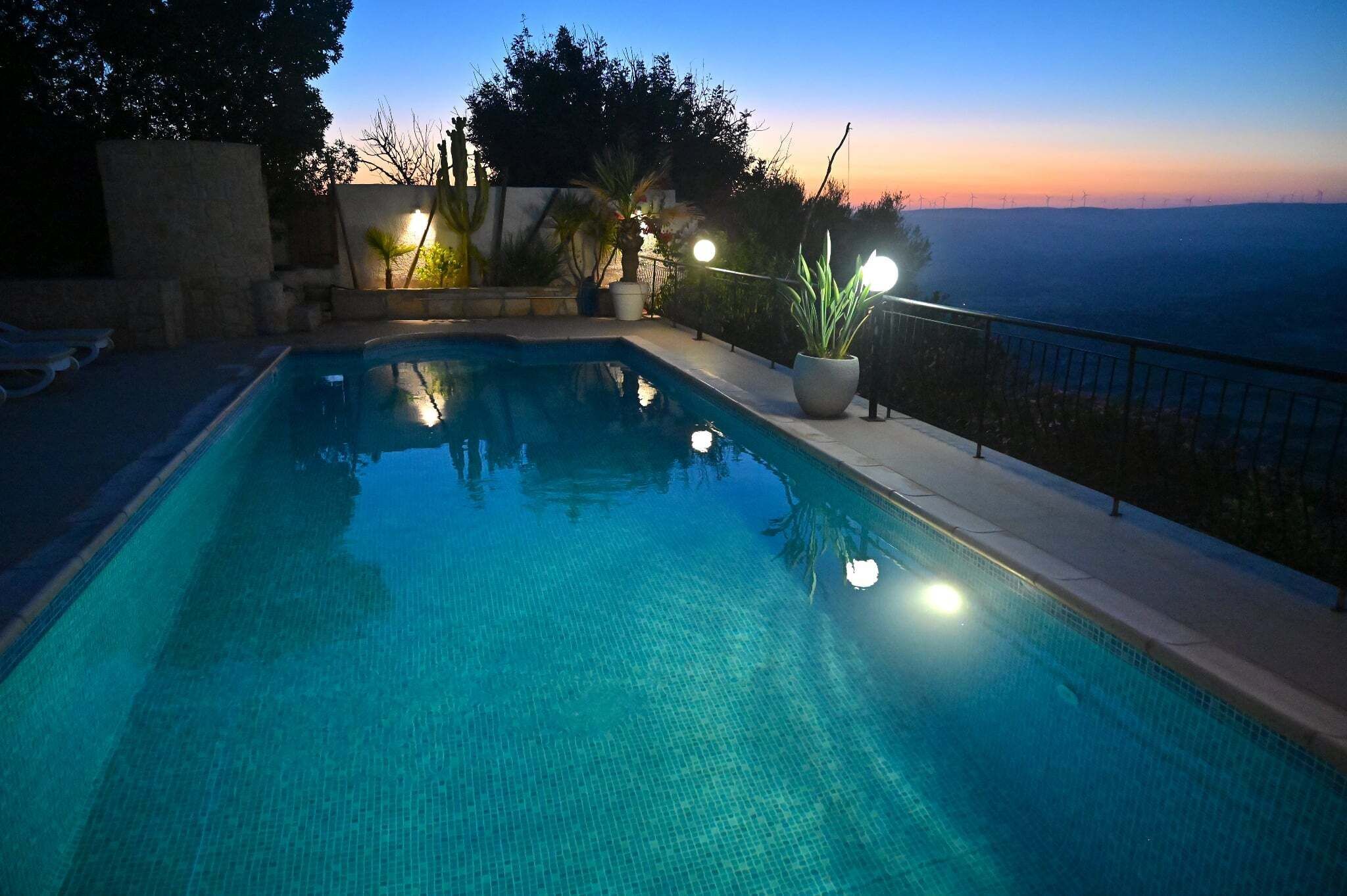 Une piscine offrant une vue sur le paysage et sur les éoliennes situées au loin.