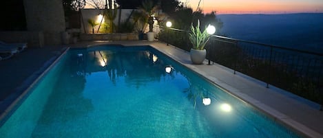 Une piscine offrant une vue sur le paysage et sur les éoliennes situées au loin.