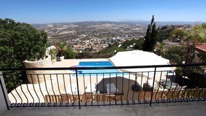 Ein Poolbereich mit Blick auf eine Stadt und Berge in der Ferne.