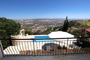 Ein Poolbereich mit Blick auf eine Stadt und Berge in der Ferne.