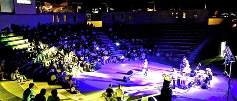 Un anfiteatro al aire libre con asientos escalonados y un escenario.