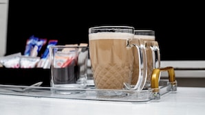 A tray with two glass mugs and a small glass on a table.