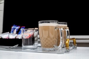 Una bandeja con dos tazas de vidrio y un vaso pequeño sobre una mesa.