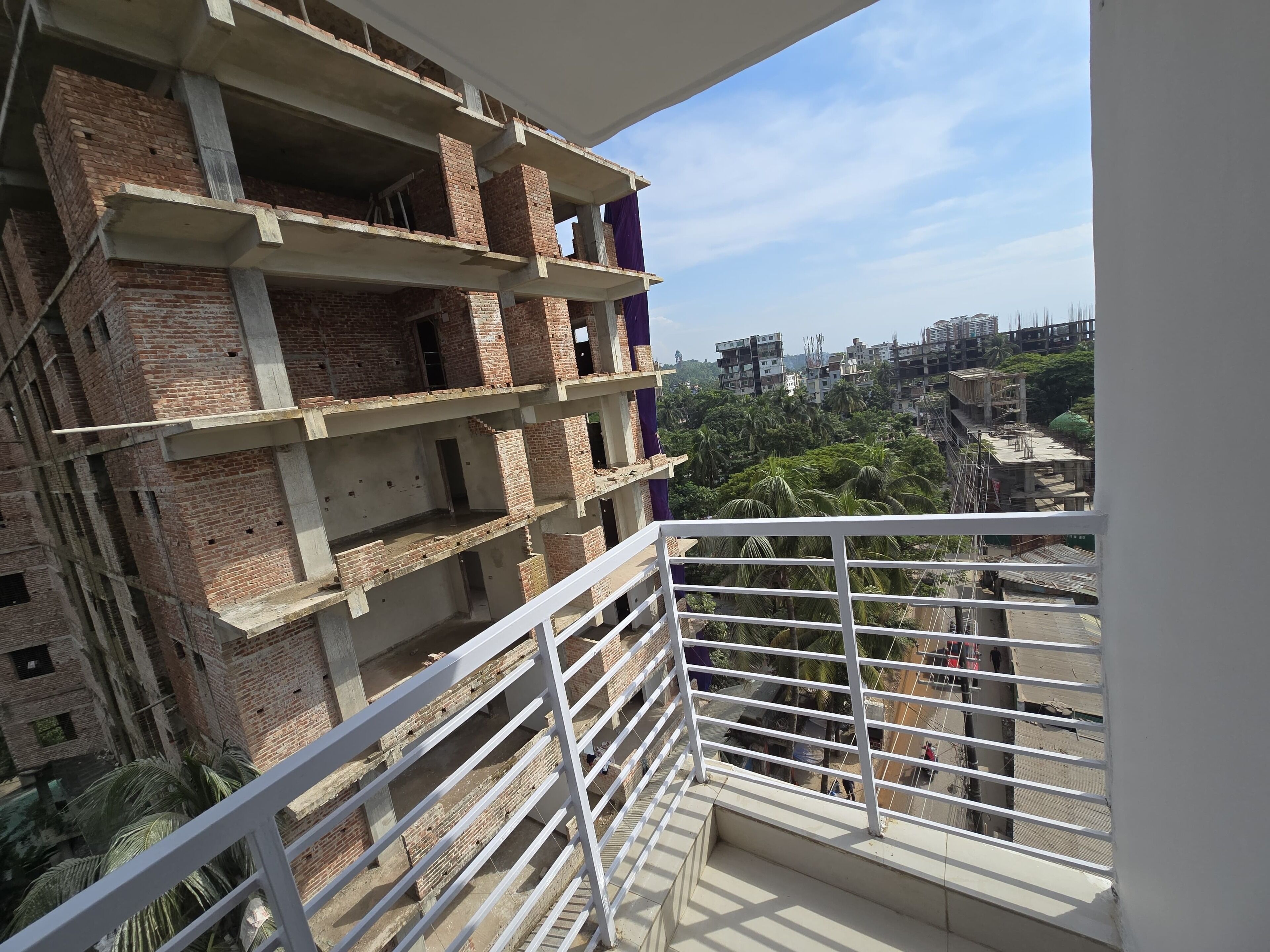 A multi-story building under construction with visible brickwork and concrete elements.