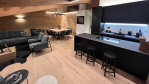 Un intérieur moderne comprenant un coin repas, une cuisine et un espace salon.