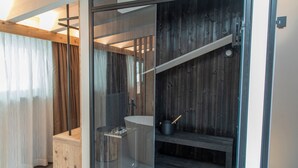 Une salle de bain moderne avec une douche à parois de verre, un banc en bois et un lavabo.