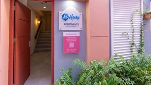 A building entrance with a sign for 'Home Apartments' and a QR code for more information. - Stylish Coral Blue Condo at Bhome Punda Residences (Willemstad)