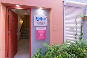 A building entrance with a sign for 'Home Apartments' and a QR code for more information. - Stylish Coral Blue Condo at Bhome Punda Residences (Willemstad)