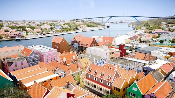 Eine Küstenstadt mit bunten Häusern und einer Brücke im Hintergrund.