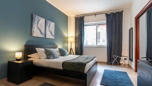 A bedroom with a bed, bedside table, lamp, and artwork on the wall. - Fourooms Bari - Principe Amedeo (Bari)