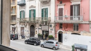 A street view with a building labeled 'al focolare' featuring a classic architectural style with balconies and shutters. - Fourooms Bari - Principe Amedeo (Bari)