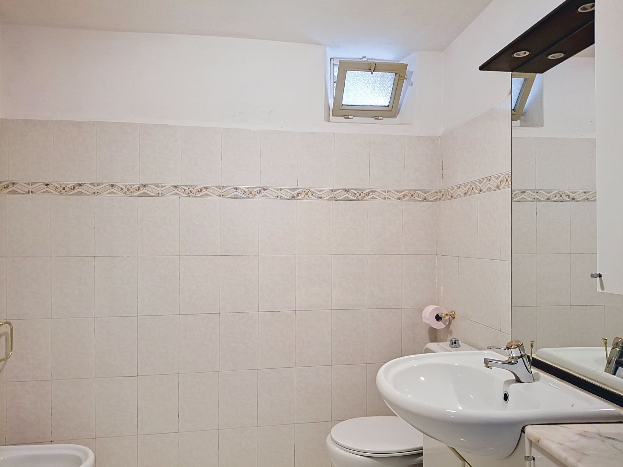 Une salle de bain équipée de toilettes, d’un bidet et d’un lavabo.