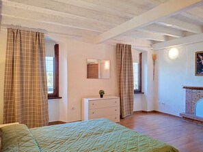 Ein Schlafzimmer mit Bett, Schminktisch, Spiegel und Kamin.
