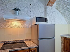 Eine Küche mit Einbauherd, einer Mikrowelle und einem Kühlschrank.