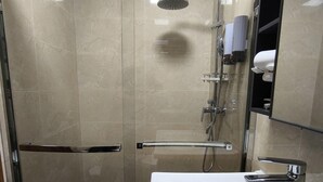 A modern bathroom with a glass-enclosed shower, a white sink, and a mirror cabinet. - Modern Studio at Megatower 7 Walk to SM, Session Rd and Burnham Park (Baguio)