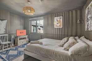 A bedroom with a bed, a television, a chair, a window, and artwork on the walls. - Guestready - Rose and Monkey (Manchester)
