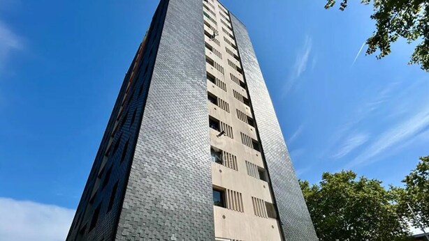 Un immeuble moderne et imposant, doté d’une façade à motifs et de nombreuses fenêtres.