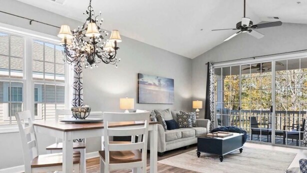 A spacious living room with a dining area, a ceiling fan, and large windows. - Barefoot Bliss-Updated 2 Bedroom, 2 Bathroom Retreat! Beach, Golf, Pools, More! (North Myrtle Beach)